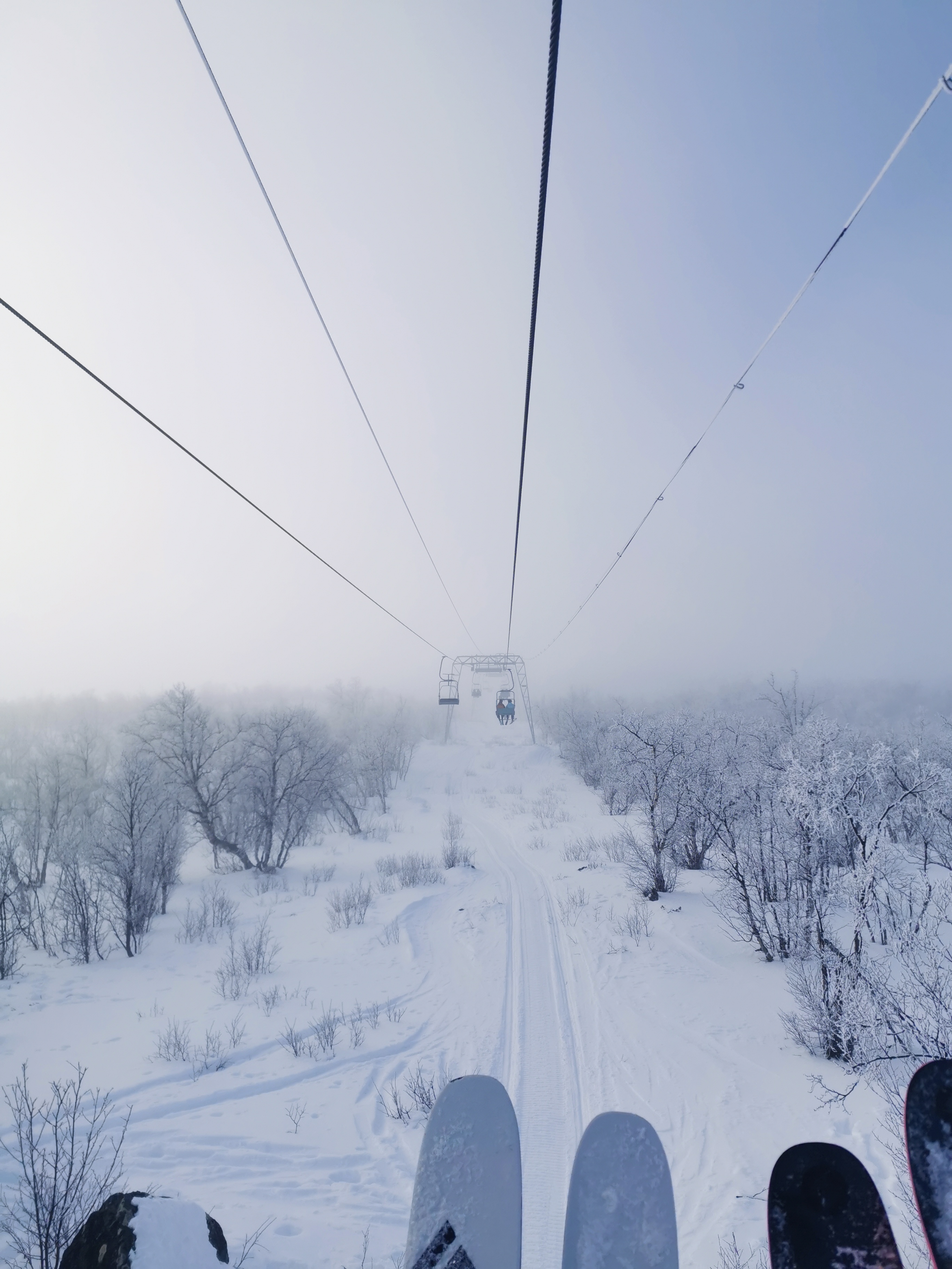 picture taken from a ski life of skiis and the foggy view